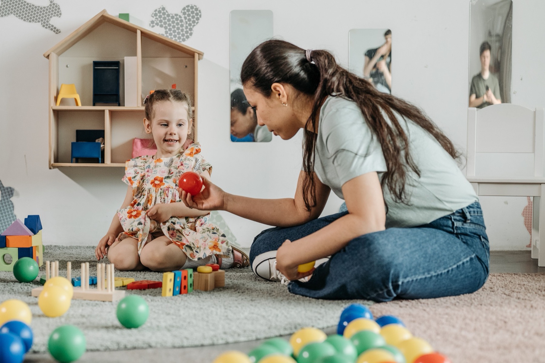 éducatrice et jeune enfant lors d'un temps d'activité dans une salle d'accueil de crèche