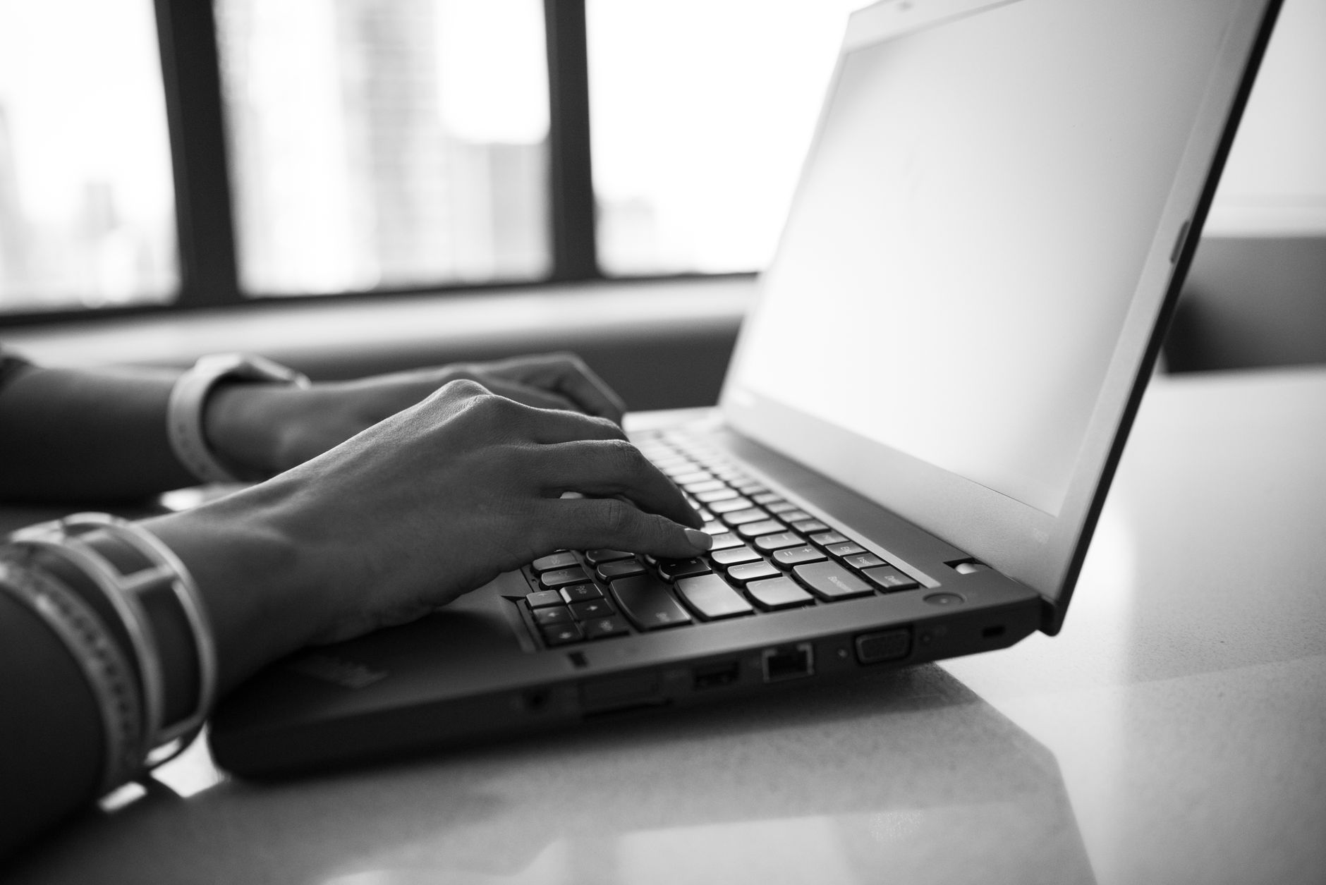 mains sur le clavier d'un ordinateur portable, en train de convertir un document en ligne