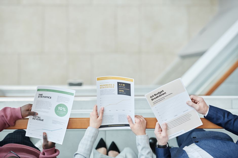 Group of business professionals analyzing financial documents in an office setting.