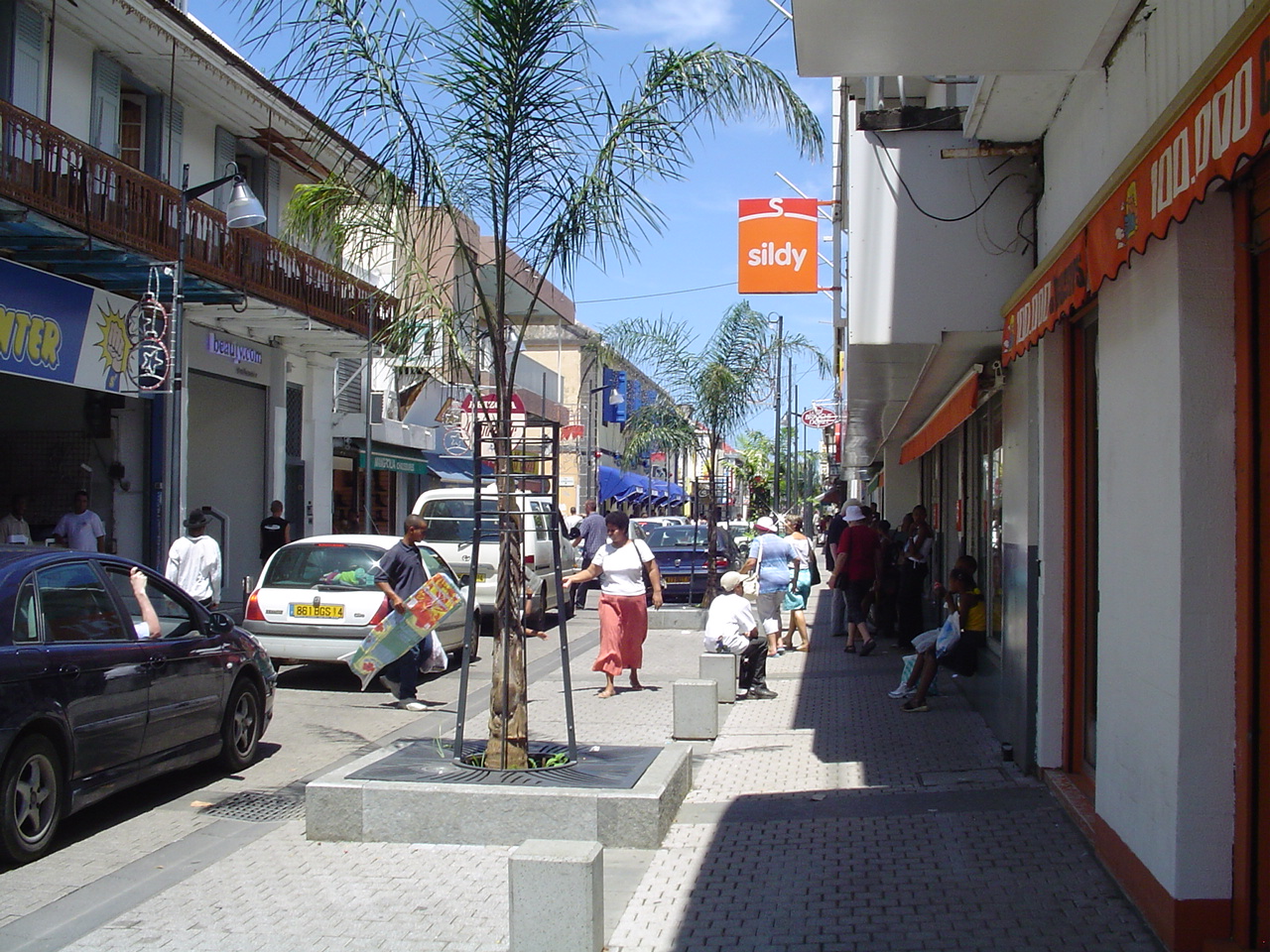 rue commerçante piétonne à Saint-Pierre, à La Réunion, bordée de boutiques et de palmiers